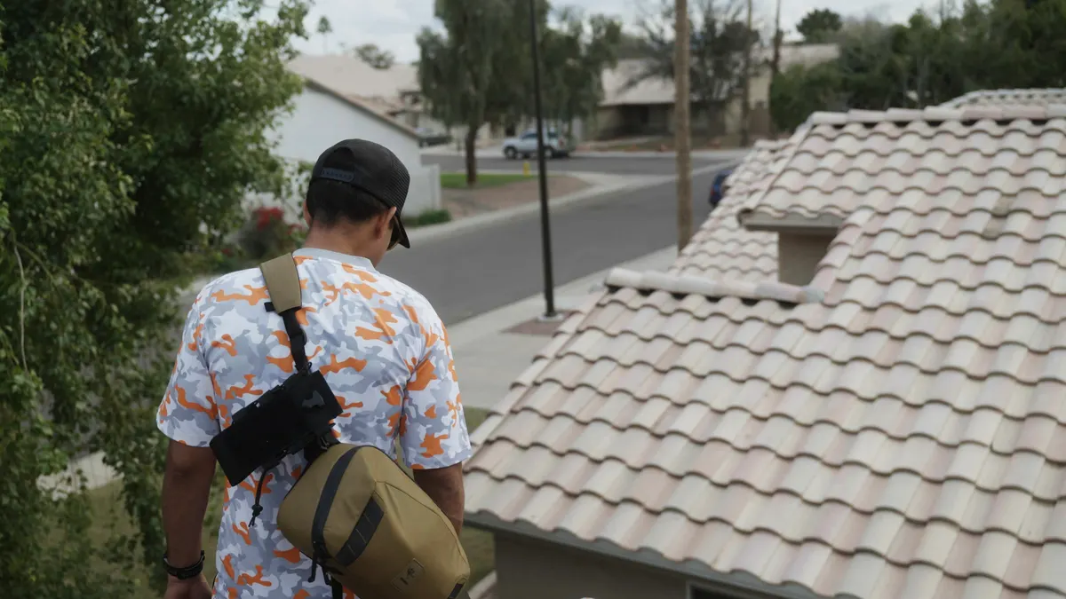 Roofer in a Simply Roofing work shirt looking over a tile roof